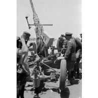 Le général Erwin Rommel accompagné d'officiers inspecte un canon de DCA anglais Bofors de 40 mm.