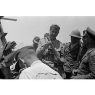 Le général Erwin Rommel accompagné d'officiers inspecte un canon de DCA anglais Bofors de 40 mm.