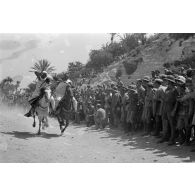 Course ou démonstration (fantasia) de cavaliers libyens entre deux haies de civils et de soldats allemands et italiens.