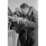 Un lieutenant (Oberleutnant) mange près d'une voiture Kfz-15.