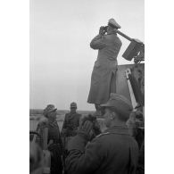Le général Erwin Rommel observe le terrain à la jumelle, debout sur un char britannique M3.