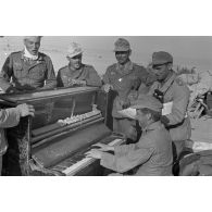 Un groupe d'officiers et de soldats allemands joue du piano et d'une contrebasse, un blindé SdKfz-232 immatriculé WH-784 231 s'est arrêté près d'eux.