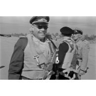 Le maréchal (Generalfeldmarschall) Kesselring, entouré d'officiers de la Luftwaffe et de la Kriegsmarine, est équipé d'un parachute.