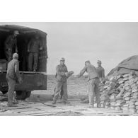 Des soldats déchargent un camion de pain.