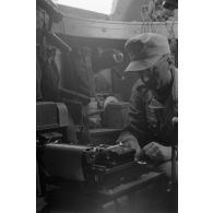 A l'intérieur d'un véhicule blindé, un soldat tape sur une machine à écrire.