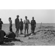 L'Oberstleutnant Karl Ens, accompagné d'officiers de l'Infanterie-Regiment 433, observe le secteur à l'aide de jumelles et discute avec les soldats.