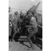 Une batterie de canons 10 cm schwere Kanone 18 règle son tir pour soutenir les blindés.