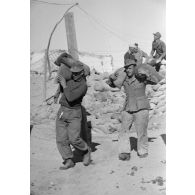 Deux soldats transportent des sacs de sable.