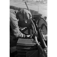 Un servant approvisionne un canon de DCA de 2 cm FlaK 38.