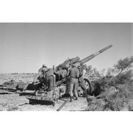 Les servants d'un canon de 10 cm K-18 en pleine action autour de la prièce d'artillerie.