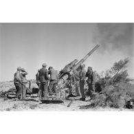 Les servants d'un canon de 10 cm K-18 en pleine action autour de la prièce d'artillerie.