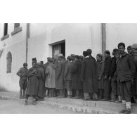 Des volontaires arabes dans les troupes allemandes patientent devant le magasin du corps pour percevoir un nouvel uniforme.
