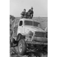 Deux soldats manoeuvrent un treuil installé sur un camion Dodge T215 d'origine américaine.