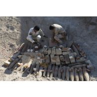 Des soldats irakiens disposent des charges explosives sur des munitions à détruire à Bagdad, en Irak.