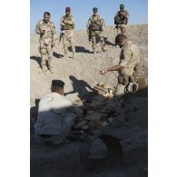 Des soldats irakiens disposent des charges explosives sur des munitions à détruire sous la supervision d'instructeurs du 2e régiment de génie (2e REG) à Bagdad, en Irak.