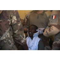 Un personnel du Service de santé malien soigne un patient pour un problème aux yeux lors d'une aide médicale à la population (AMP) de Tessit, au Mali.