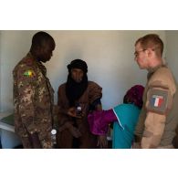 Un personnel du Service de santé malien relève la tension artérielle d'un patient lors d'une aide médicale à la population (AMP) de Tessit, au Mali.
