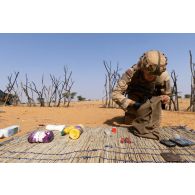 Un soldat du peloton de reconnaissance et d'intervention (PRI) aligne des détonateurs trouvés lors d'une fouille du village d'Ag Dembou dans la région de Tessit, au Mali.
