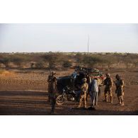 Des soldats du peloton de reconnaissance et d'intervention (PRI) accompagnés de soldats maliens contrôlent l'identité d'un motard intercepté dans la région de Tessit, au Mali.
