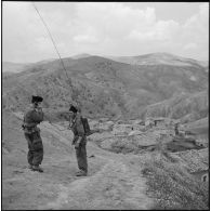 Communication radio sur un poste SCR-300 par des soldats du 72e GA (groupe d'artillerie) à l'entrée du village de Bou Arroua.