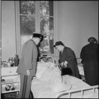 Visite de Mme Lacoste, femme de Robert Lacoste (gouverneur général d'Algérie) aux blessés de l'hôpital Maillot d'Alger.