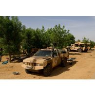 Un pick-up Acmat light tactical vehicle (ALTV) et un véhicule léger de reconnaissance et d'appui (VLRA) de l'armée malienne stationnent sur un lieu de bivouac à Gao, au Mali.