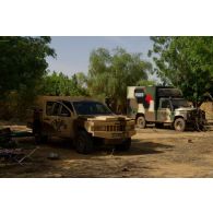 Un pick-up Acmat light tactical vehicle (ALTV) et une ambulance Kia KM 451 de l'armée malienne stationnent sur un lieu de bivouac à Gao, au Mali.