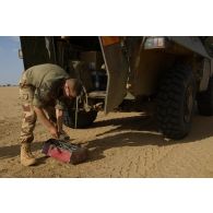 Un mécanicien du 1er peloton de circulation du 515e régiment du train (515e RT) débarque de son véhicule de l'avant blindé (VAB) et prépare ses outils pour une intervention sur la route de Tessalit, au Mali.