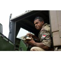 Un brigadier-chef du 3e escadron de transport du 515e régiment du train (515e RT) profite d'une pause pour manger sa ration à bord de son camion CBH-385 lors d'une halte en direction de Gao, au Mali.