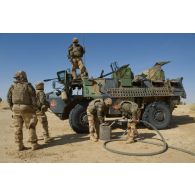 Des marsouins du 3e régiment d'infanterie de marine (3e RIMa) remplissent leur jerrican d'essence lors d'une halte au nord de Bamba, au Mali.