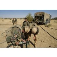 Des marsouins du 3e régiment d'infanterie de marine (3e RIMa) recomplètent leurs jerricans en carburant au moyen d'un camion-citerne polyvalent de 10 m3 (CCP 10) lors d'une halte au nord de Bamba, au Mali.