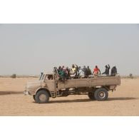 Des habitants sont convoyés par camion utilisé comme moyen de transport en commun sur la route de Tessalit, au Mali.