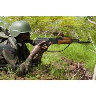 Un soldat malien sécurise le périmètre sous couvert des buissons lors d'un exercice à Koulikoro, au Mali.