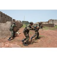 Un trinôme de combat progresse entre les bâtiments lors d'un exercice à Koulikoro, au Mali.