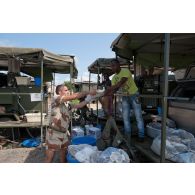 L'adjudant-chef Francis distribue des sacs de lessive au personnel malien en charge de la laverie du camp de Bamako, au Mali.