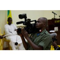 Un caméraman de la Direction de l'information et des relations publiques des armées (DIRPA) filme une conférence à l'école de maintien de la paix à Bamako, au Mali.