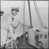 Le lieutenant de vaisseau Piquet observant les pêcheurs manoeuvrer leur bateau.