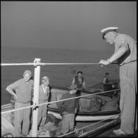 Des marins regardant les pêcheurs dans leurs embarcations 