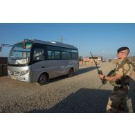 Un bigor du 3e régiment d'artillerie de marine (3e RAMa) encadre l'arrivée d'un autobus au poste de sécurité du camp de Bamako, au Mali.