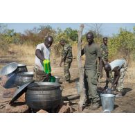 Des soldats maliens préparent l'ordinaire en bivouac sur le camp de Koulikoro, au Mali.