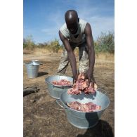 Un soldat malien dispose la viande pour la préparation de l'ordinaire en bivouac sur le camp de Koulikoro, au Mali.