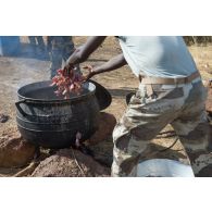 Un soldat malien dispose la viande pour la préparation de l'ordinaire en bivouac sur le camp de Koulikoro, au Mali.