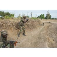 Des soldats maliens progressent vers une cible ennemie abattue jouée par un instructeur estonien lors d'une formation à Koulikoro, au Mali.
