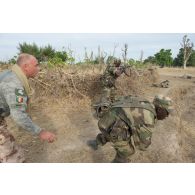 Un instructeur lituanien encadre la progression de soldats maliens vers une cible adverse abattue jouée par un instructeur estonien lors d'une formation à Koulikoro, au Mali.