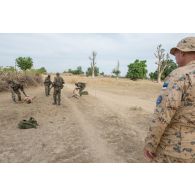 Des soldats maliens vérifient la neutralisation de cibles ennemies jouées par des instructeurs estoniens lors d'une formation à Koulikoro, au Mali.