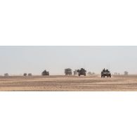 Les véhicules d'un convoi arrivent sur l'emplacement d'une base opérationnelle avancée temporaire (BOAT) pour une halte dans le désert malien.
