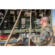 Un logisticien du Service des essences des armées (SEA) contrôle la sortie de carburant à l'arrière de son camion-citerne polyvalent de 10m3 (CCP10) dans le désert malien.