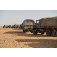 Les véhicules d'un convoi se présentent en colonne pour leur ravitaillement en carburant lors d'une halte dans le désert malien.
