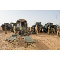 Des soldats déploient leurs lits Picot pour passer la nuit en bivouac sur une base opérationnelle avancée temporaire (BOAT) dans le désert malien.