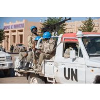 Des casques bleus burkinabè s'apprêtent à patrouiller à bord de leur pick-up dans les rues de Tombouctou, au Mali.